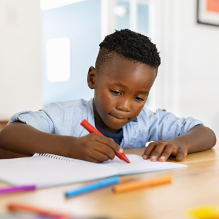 Image of child writing on paper